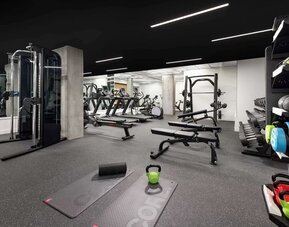 Fully equipped fitness center with weights, benches, and cardio machines at Timbri Hotel San Francisco, Curio Collection By Hilton.