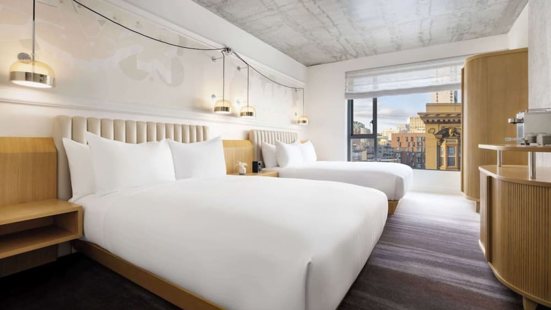 Stylish double room with two beds, warm lighting, contemporary décor, and city-facing window at Timbri Hotel San Francisco, Curio Collection By Hilton.
