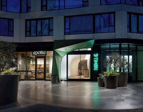 Exterior entrance of the hotel at night with illuminated signage and contemporary design at Timbri Hotel San Francisco, Curio Collection By Hilton.