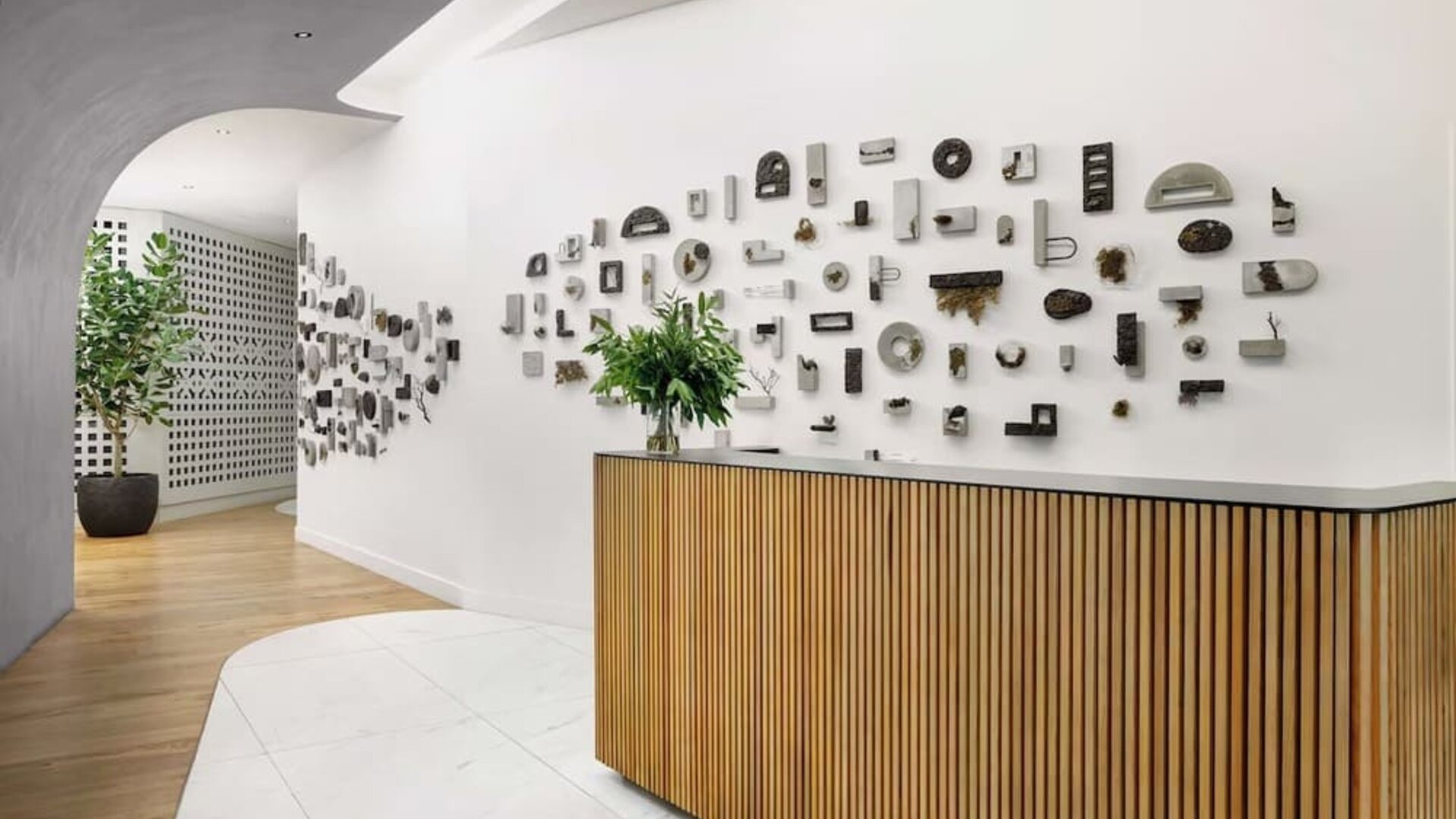 Reception area with wooden desk, artistic wall installation, and minimalist design at Timbri Hotel San Francisco, Curio Collection By Hilton.