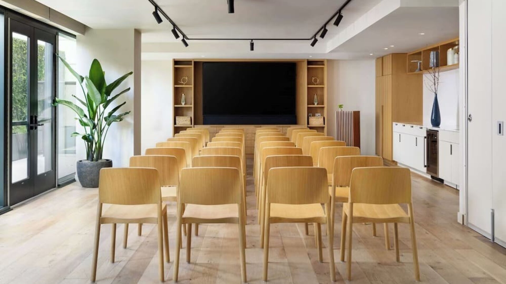 Meeting room set up in theatre style with wooden chairs and presentation screen at Timbri Hotel San Francisco, Curio Collection By Hilton.