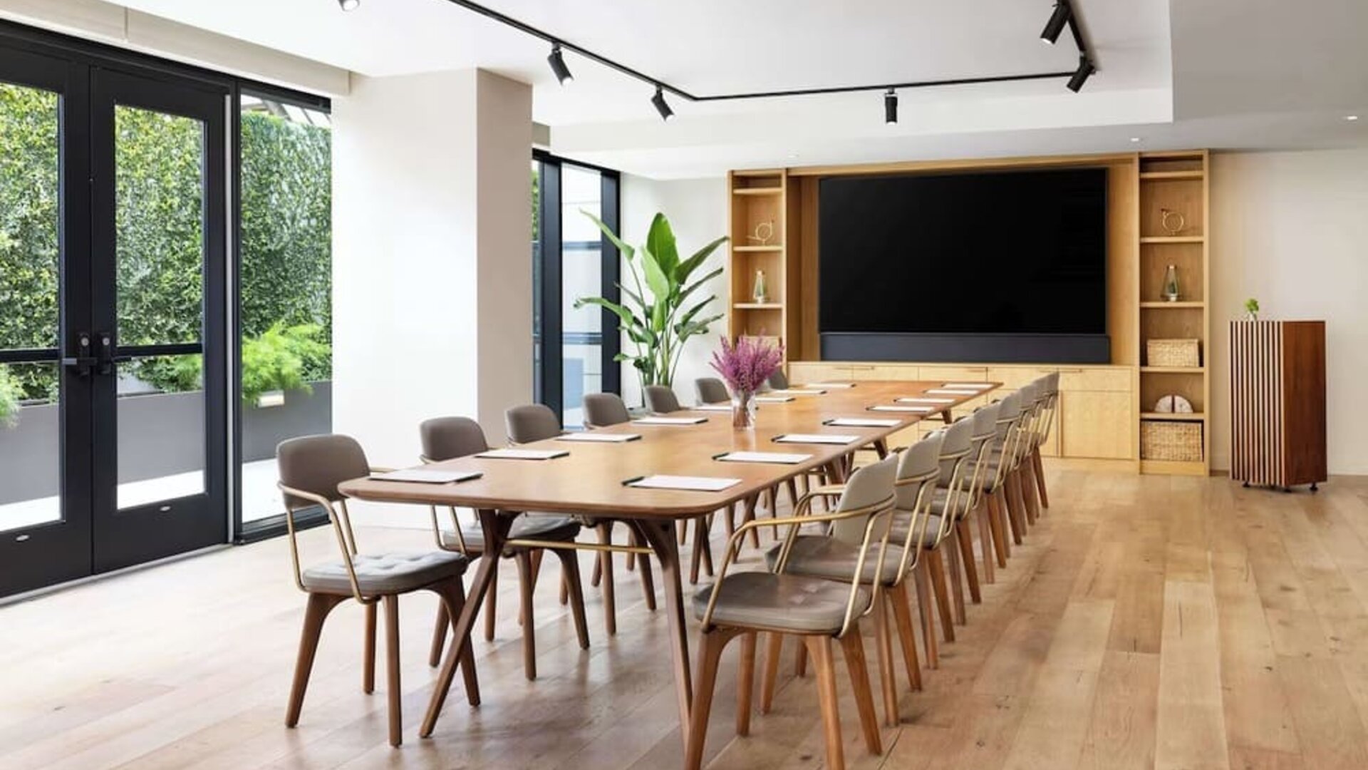 Conference room with long table, chairs, and presentation setup at Timbri Hotel San Francisco, Curio Collection By Hilton.