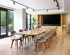 Conference room with long table, chairs, and presentation setup at Timbri Hotel San Francisco, Curio Collection By Hilton.
