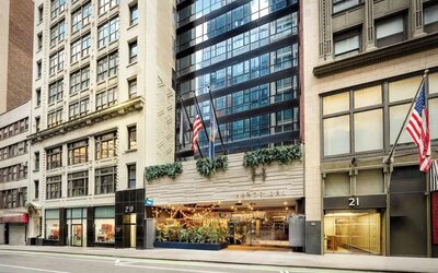 Hotel entrance with signage, greenery, and welcoming street-level access at Hotel Hendricks.