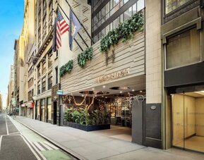 Exterior view of Hotel Hendricks with street-facing entrance and surrounding city buildings.