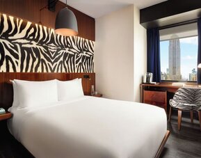 Bright room with natural light, workspace, and city skyline views at Hotel Hendricks.