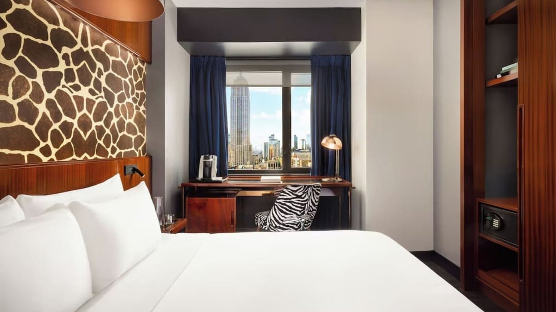 Guest room with desk setup, coffee station, and city-facing window at Hotel Hendricks.