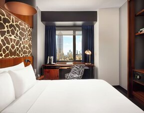 Guest room with desk setup, coffee station, and city-facing window at Hotel Hendricks.