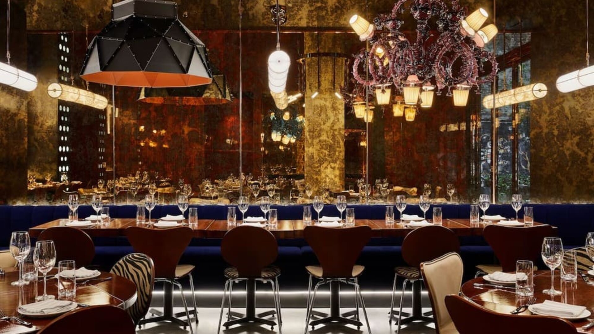 Upscale dining area with ambient lighting, chandeliers, and elegant table settings at Hotel Hendricks.