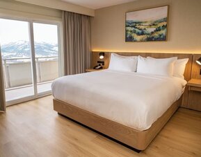 King bed with balcony and outside view at DoubleTree By Hilton Wilkes-Barre.