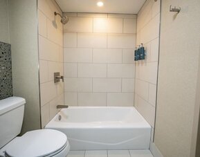 Guest bathroom with bath and shower at DoubleTree By Hilton Wilkes-Barre.