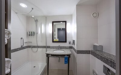 Guest bathroom with bath and shower at Hampton By Hilton Liverpool/John Lennon Airport.