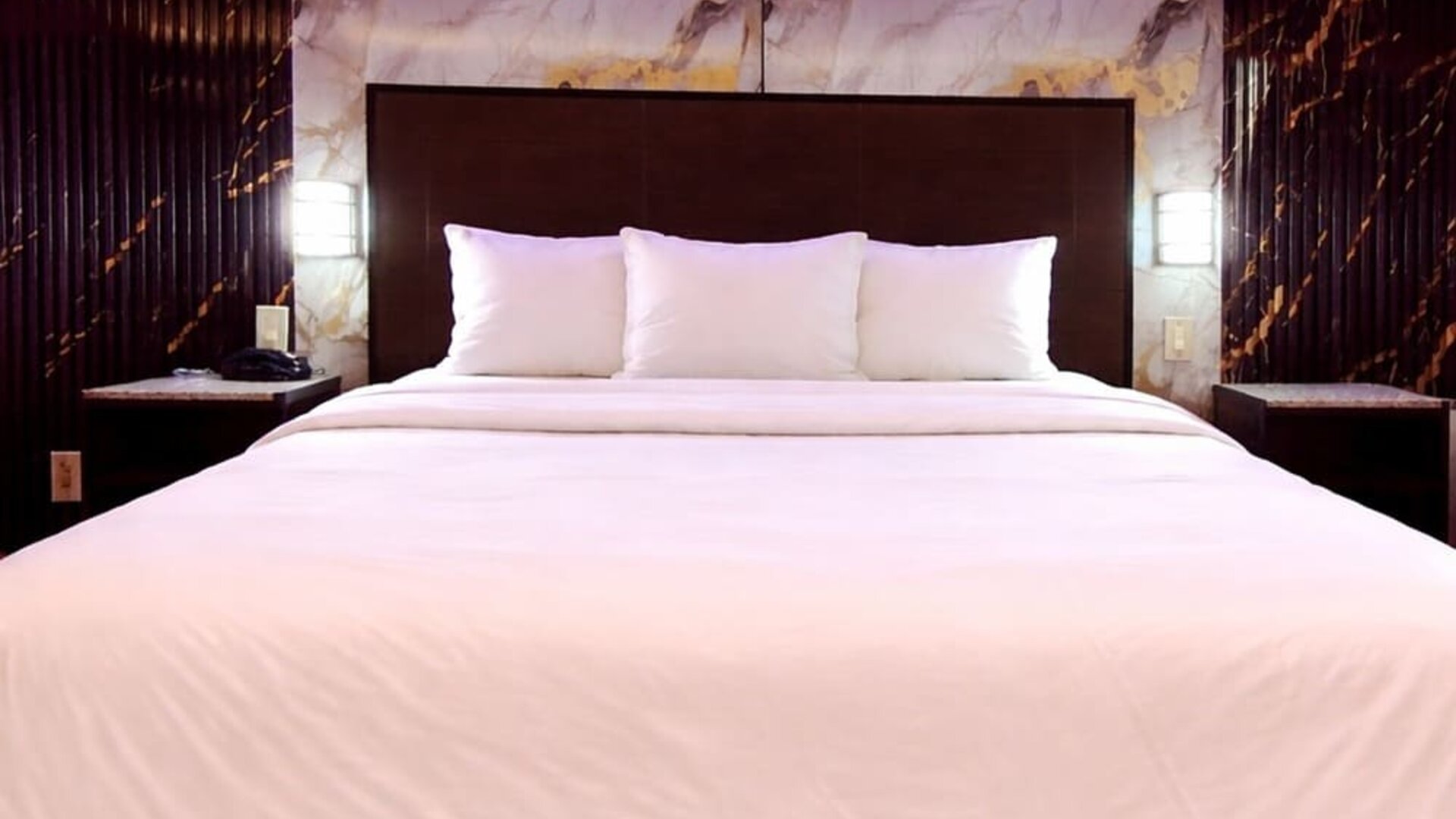 King room with sleek headboard, marble accent wall, and soft LED lighting for a contemporary feel at Imperial Hotel.