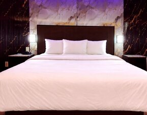 King room with sleek headboard, marble accent wall, and soft LED lighting for a contemporary feel at Imperial Hotel.