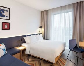 Cozy delux king room with couch at Hampton By Hilton Tallinn.