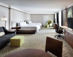 Spacious king suite with couch and TV at Hilton Garden Inn Montreal Airport.