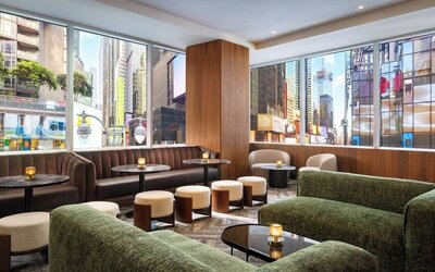 Lounge seating area with city views, sofas, and tables at Hyatt Regency Times Square.