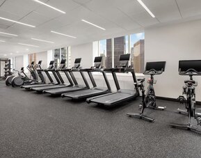 Fitness center with treadmills, bikes, and floor-to-ceiling windows at Hyatt Regency Times Square.