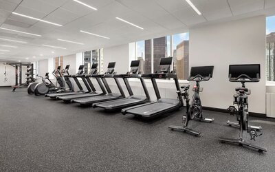 Fitness center with treadmills, bikes, and floor-to-ceiling windows at Hyatt Regency Times Square.