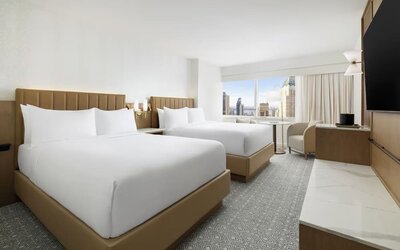 Guest room with two beds, seating, and city views at Hyatt Regency Times Square.