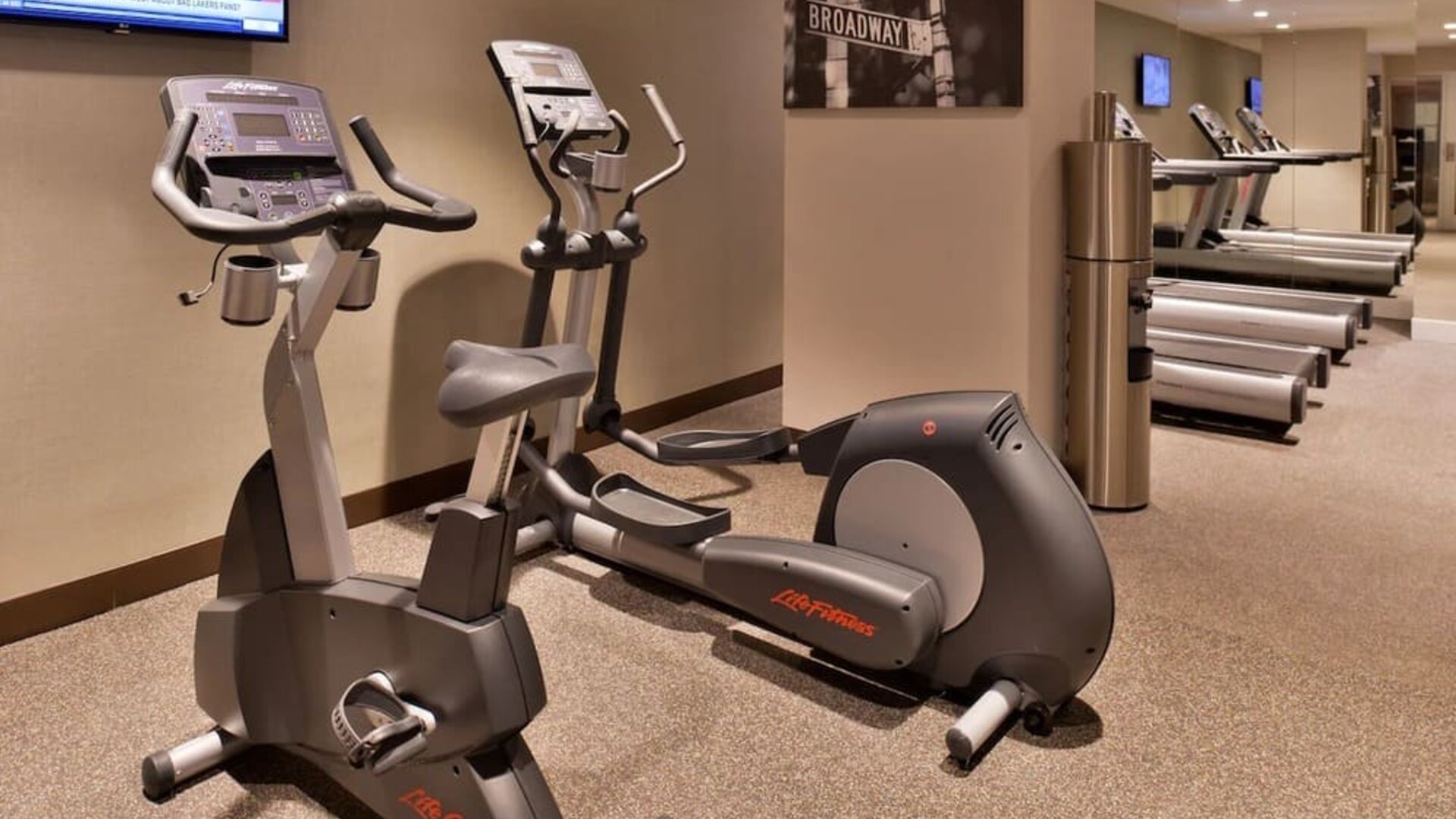 Fitness center with cardio machines including elliptical and exercise bike at Holiday Inn New York City - Times Square By IHG.