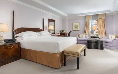 Bedroom with natural light, plush bedding, and comfortable seating at The Michelangelo New York.
