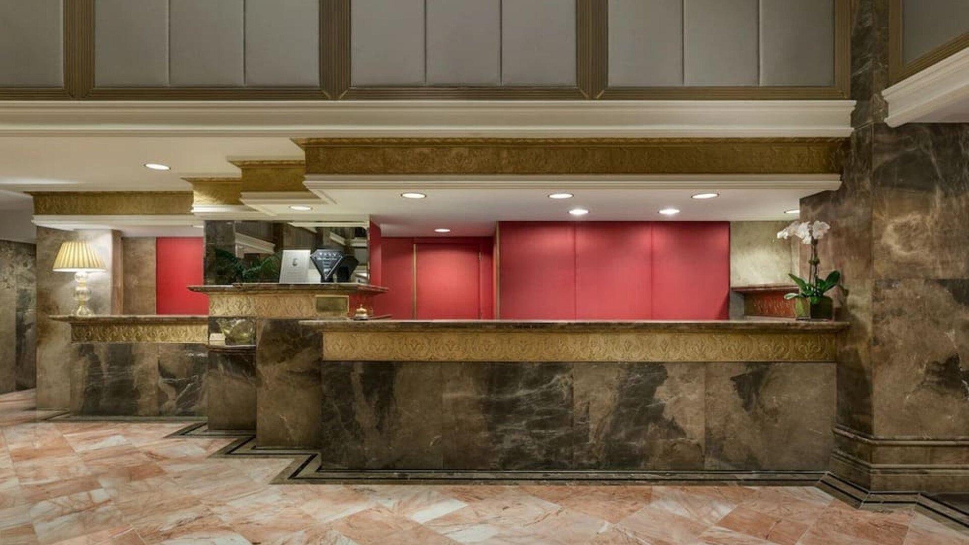 Reception desk area with marble finishes and warm lighting at The Michelangelo New York.