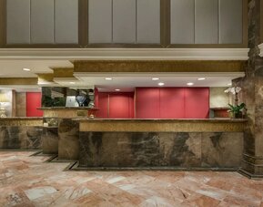 Reception desk area with marble finishes and warm lighting at The Michelangelo New York.