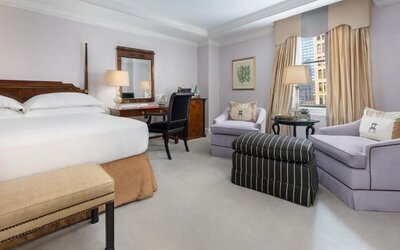 Classic guest room with plush bedding, writing desk, and elegant seating area at The Michelangelo New York.