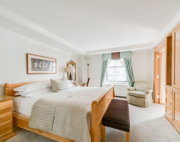 Spacious bedroom with king bed, seating area, and elegant decor at The Michelangelo New York.