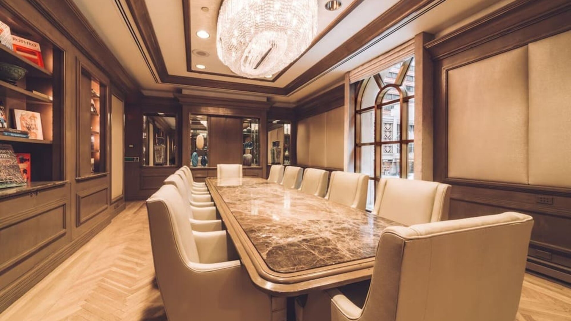 Meeting room with long conference table, chandelier lighting, and wood-paneled walls at The Michelangelo New York.