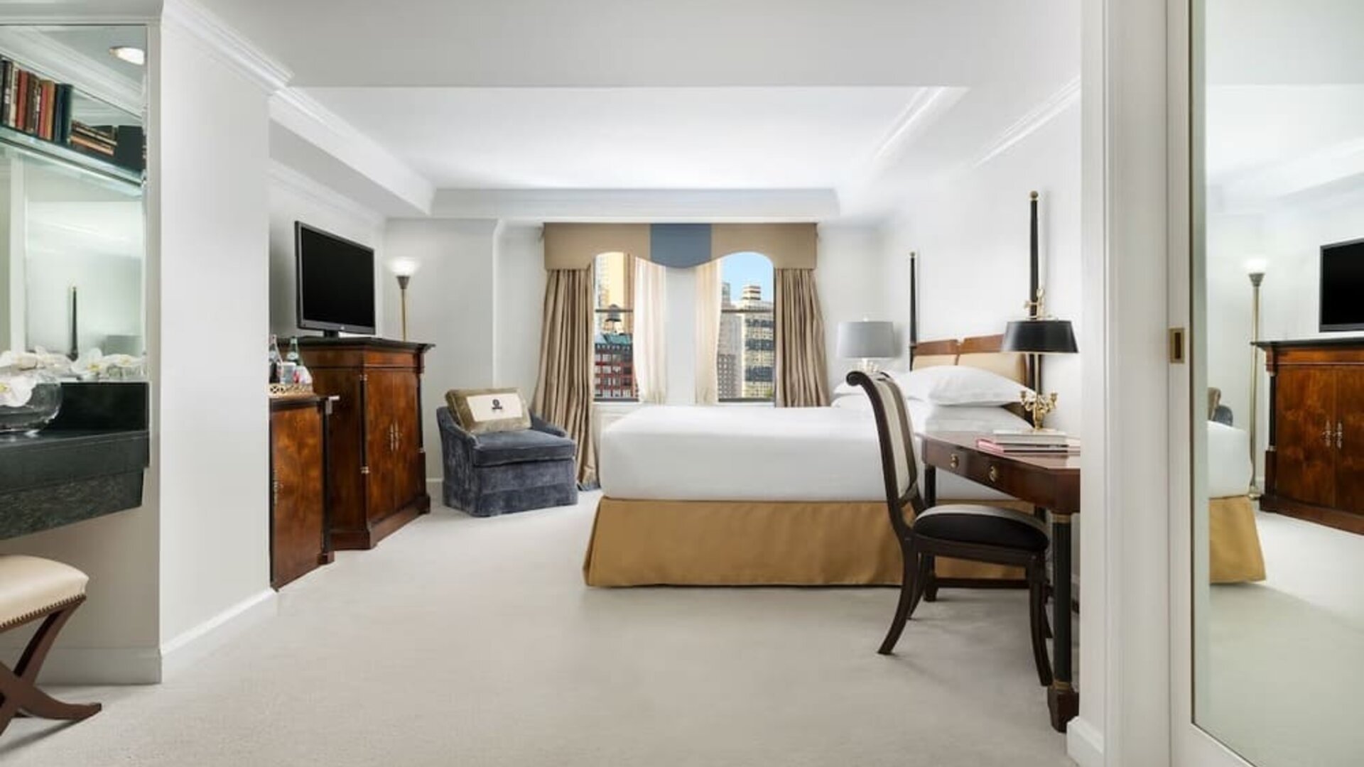 Spacious suite with separate living area, desk workspace, and city views at The Michelangelo New York.