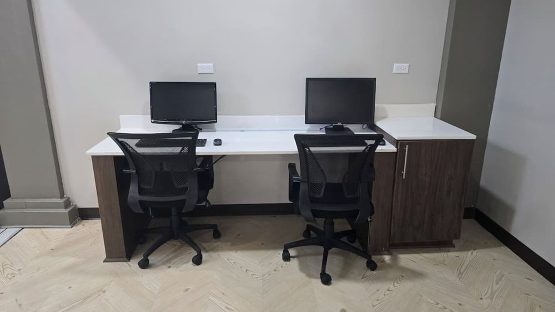 Business center with dual workstations, desktop computers, and ergonomic seating at Wyndham Garden Williamsburg Busch Gardens Area.