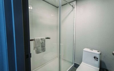 Bathroom with glass-enclosed shower, tiled walls, and modern fixtures at Wyndham Garden Williamsburg Busch Gardens Area.