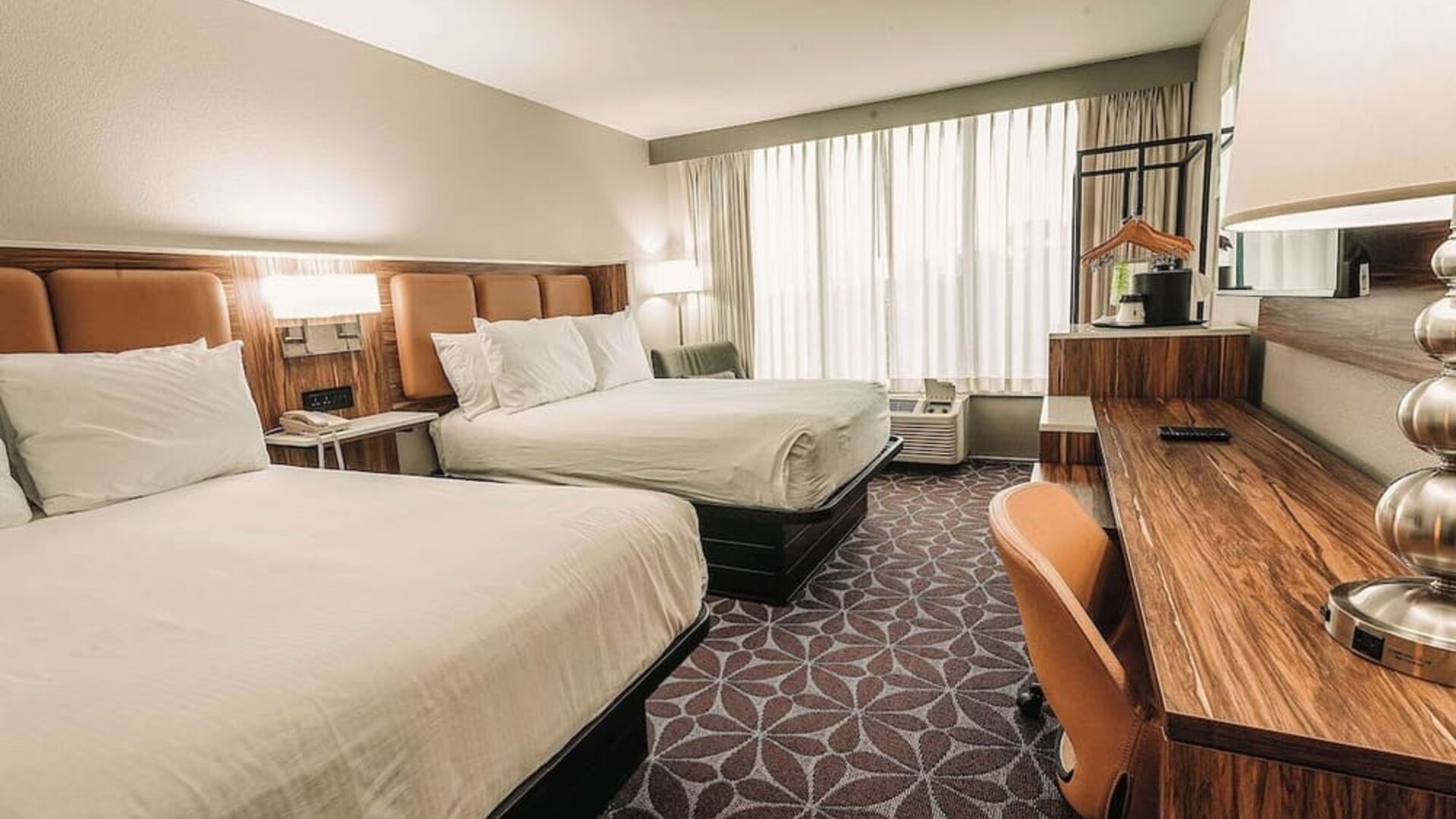 Double room with two beds, workspace, and modern decor at Wyndham Garden Williamsburg Busch Gardens Area.