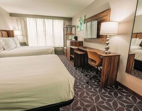 Two-bed guest room with desk, mirror, and contemporary design at Wyndham Garden Williamsburg Busch Gardens Area.