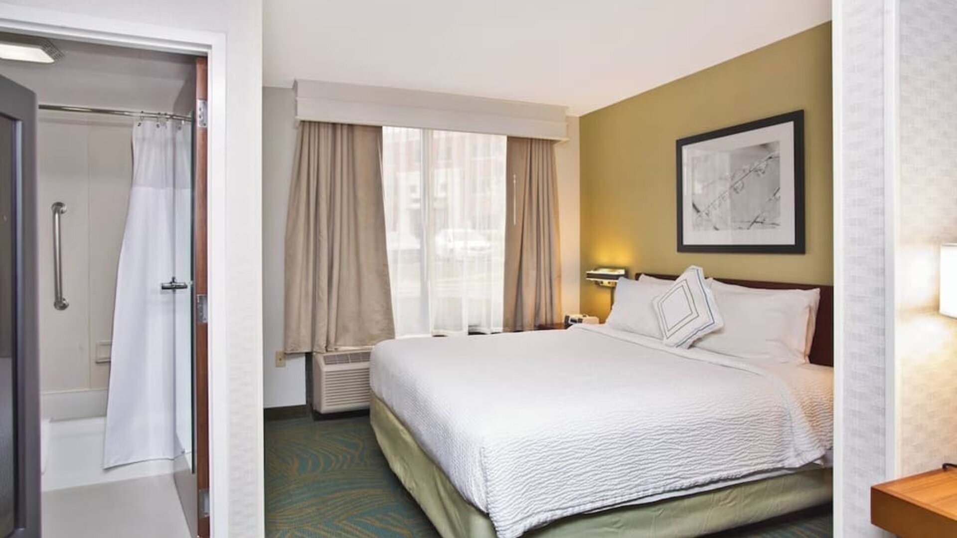 King guest room with white bedding, work desk, window seating area, and accessible bathroom at Marriott SpringHill Suites Naperville/Warrenville.