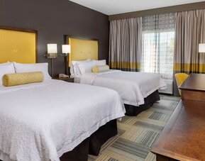 Guest room with two beds, yellow headboards, window seating, and coordinated décor at Hampton Inn & Suites Los Angeles / Hollywood.