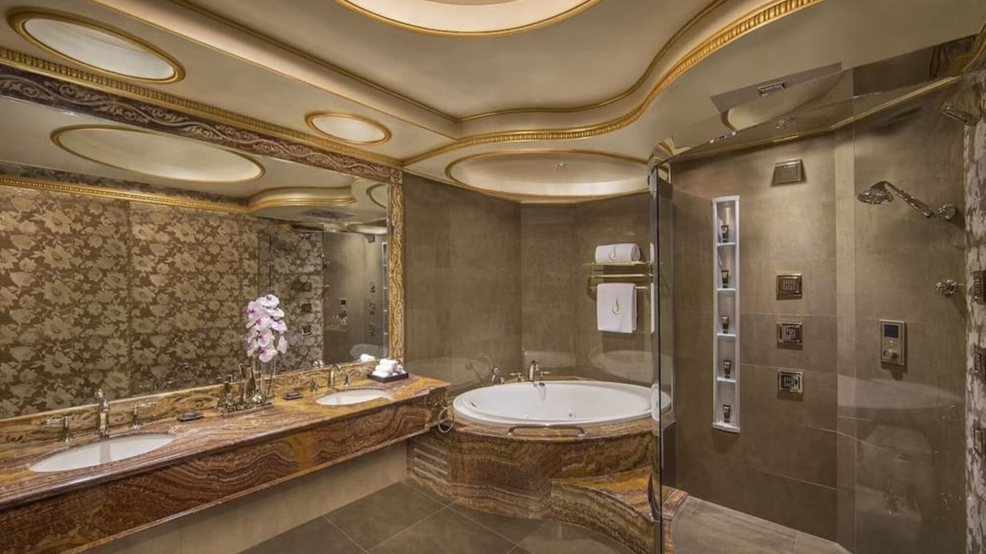 Large marble bathroom with soaking tub, glass shower, dual sinks, and decorative ceiling panels