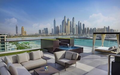 Rooftop lounge with seating, small plunge pool, cabana daybeds, and panoramic skyline views