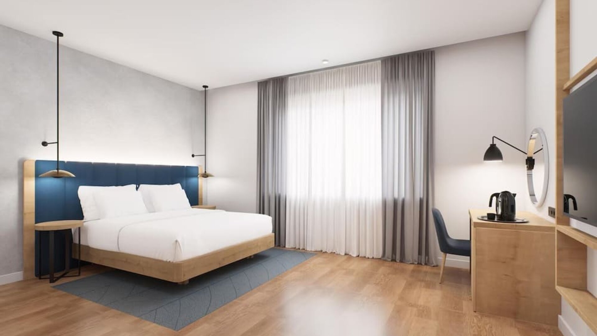 Spacious king room with blue headboard, large curtained window, desk area, and wall-mounted TV