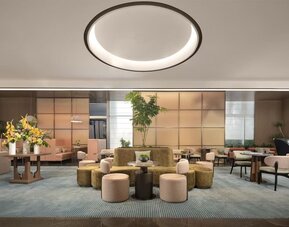 Contemporary lobby lounge with circular seating, floral arrangement, and soft ambient lighting