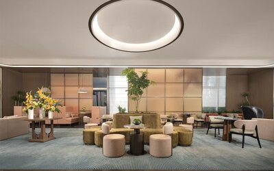 Contemporary lobby lounge with circular seating, floral arrangement, and soft ambient lighting