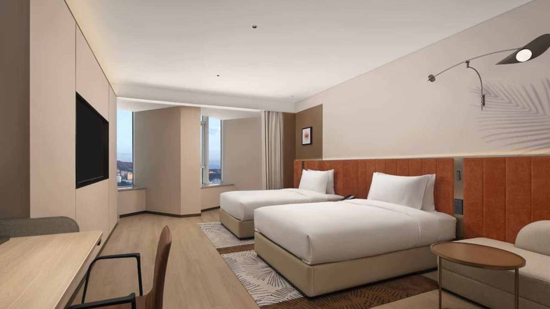 Modern guest room with two double beds, wall-mounted TV, desk area, and corner city windows