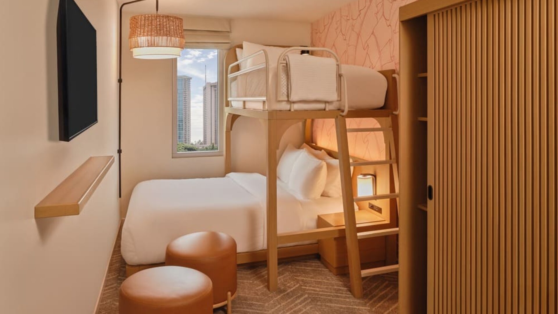 Guest room with two beds, modern headboard, and balcony seating area at The Ambassador Hotel Of Waikiki.