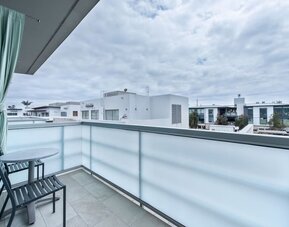 Private balcony with two chairs, small table, and neighborhood views at Shade Hotel Manhattan Beach.