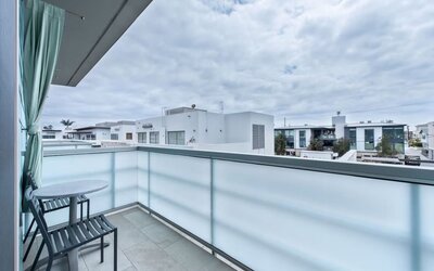 Private balcony with two chairs, small table, and neighborhood views at Shade Hotel Manhattan Beach.
