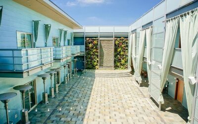 Open-air courtyard with tiled walkways, lounge areas, and vertical garden wall at Shade Hotel Manhattan Beach.