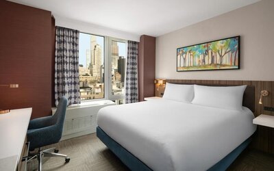 King bedroom with city views and workspace at Hilton Garden Inn New York/West 35th Street.
