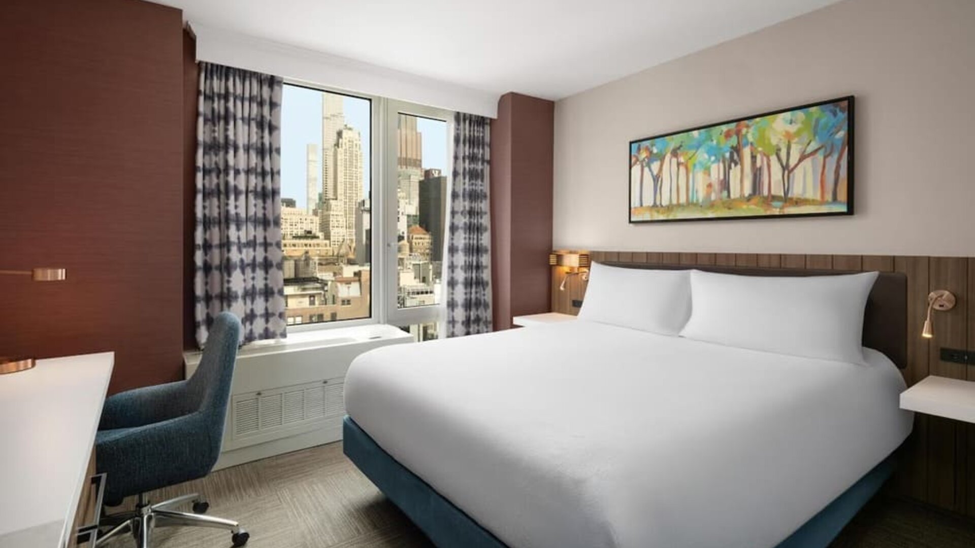 King bedroom with city views and workspace at Hilton Garden Inn New York/West 35th Street.